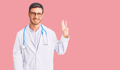 Handsome young man with bear wearing doctor uniform showing and pointing up with fingers number three while smiling confident and happy.