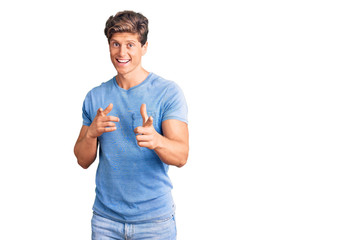 Young handsome man wearing casual clothes pointing fingers to camera with happy and funny face. good energy and vibes.