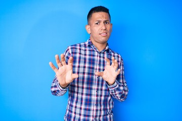 Young handsome latin man wearing casual clothes disgusted expression, displeased and fearful doing...