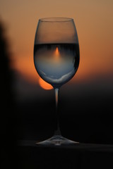 Reflection of the sun and sunset in a refreshing glass of wine.
