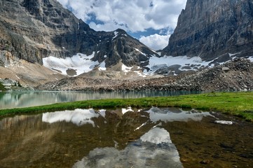 Reflection of glaciers and mountains in small lake. Opabin lake and lake O'Hara. Yoho Park. British Columbia. Canada 