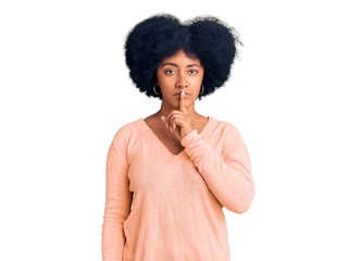 Young african american girl wearing casual clothes asking to be quiet with finger on lips. silence and secret concept.