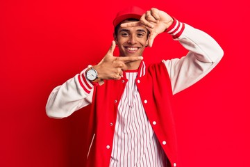 Young african amercian man wearing baseball uniform smiling making frame with hands and fingers with happy face. creativity and photography concept.