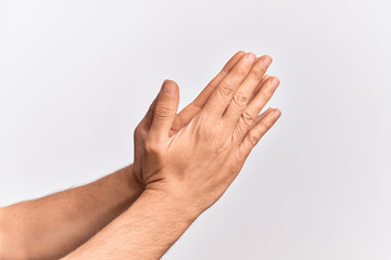Hand of caucasian young man showing fingers over isolated white background touching palms praying with both hands together, catholic religious symbol