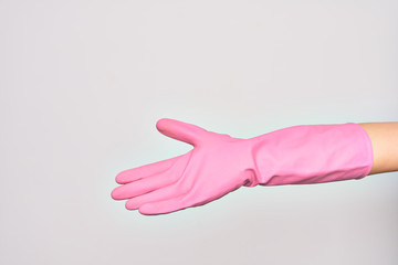 Hand of caucasian young woman wearing pink cleaning glove doing give me sign. Showing opened empty palm over isolated white background