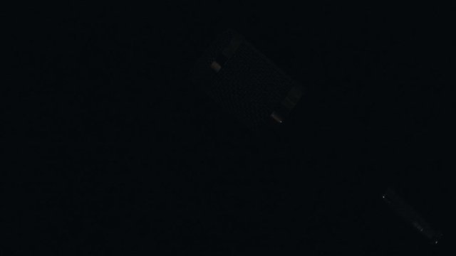 Micr&oacute;fono profesional de sobre mesa con cable y montado en su base con un fondo negro, e iluminaci&oacute;n en movimiento.