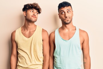 Fototapeta na wymiar Young gay couple wearing casual clothes smiling looking to the side and staring away thinking.