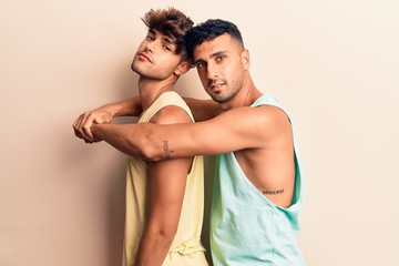 Young couple of men wearing summer clothes smiling happy. Standing with smile on face hugging over isolated white background - obrazy, fototapety, plakaty