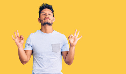 Handsome latin american young man wearing casual clothes relax and smiling with eyes closed doing meditation gesture with fingers. yoga concept.