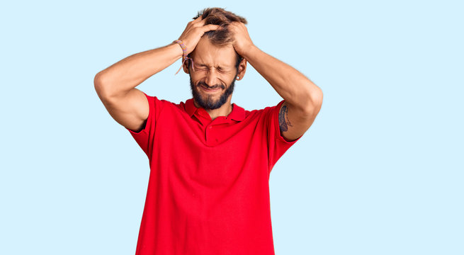 Handsome blond man with beard wearing casual clothes suffering from headache desperate and stressed because pain and migraine. hands on head.