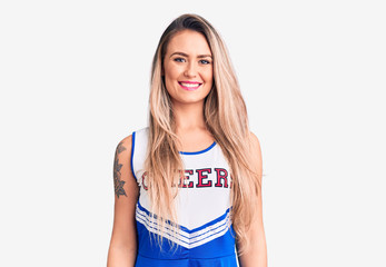Young beautiful blonde woman wearing cheerleader uniform with a happy and cool smile on face. lucky...