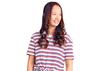 Fototapeta premium Young beautiful chinese girl wearing casual clothes looking away to side with smile on face, natural expression. laughing confident.