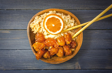 Chinese Food Sweet and Sour, Orange or Lemon Chicken with rice in wooden bowl on rustic table