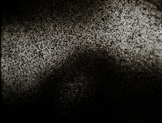 Abstract dark textuded surface with light and shadow areas.