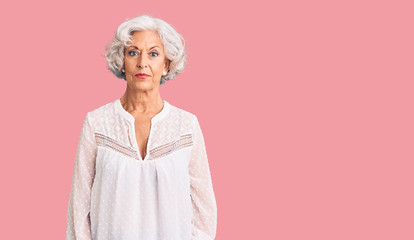 Senior grey-haired woman wearing casual clothes relaxed with serious expression on face. simple and natural looking at the camera.