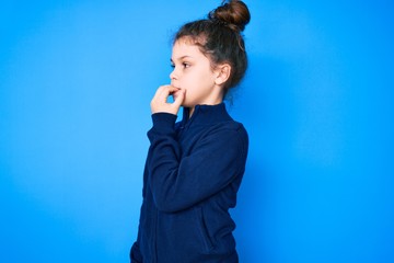 Cute hispanic child wearing casual clothes looking stressed and nervous with hands on mouth biting nails. anxiety problem.