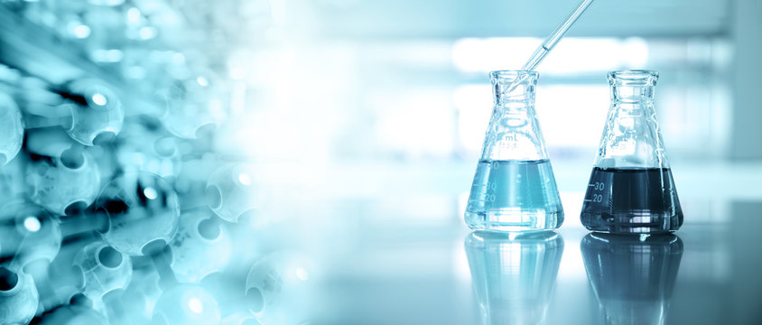 two glass flask with dropper and molecular chemistry on blue science laboratory background