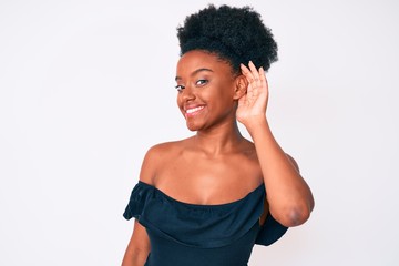 Young african american woman wearing casual clothes smiling with hand over ear listening an hearing to rumor or gossip. deafness concept.