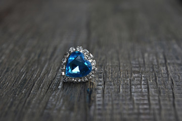 
White gold necklace pendant
Heart shaped aquamarine rests on the wooden floor.