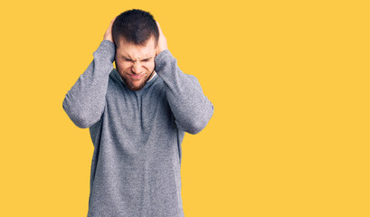 Young handsome man wearing casual sweater suffering from headache desperate and stressed because pain and migraine. hands on head.