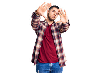 Young handsome man wearing casual shirt doing frame using hands palms and fingers, camera perspective