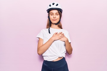 Young beautiful girl wearing bike helmet smiling with hands on chest, eyes closed with grateful gesture on face. health concept.