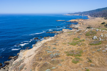 Fototapeta na wymiar The Pacific Ocean washes along the rugged shoreline of Northern California on a calm day. This part of the west coast is one of the most beautiful areas in the United States.
