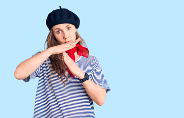 Young beautiful blonde woman wearing french beret and striped t-shirt doing time out gesture with hands, frustrated and serious face