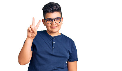 Naklejka premium Little boy kid wearing casual clothes and glasses showing and pointing up with fingers number two while smiling confident and happy.