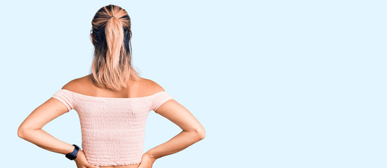Young beautiful woman wearing casual clothes standing backwards looking away with arms on body