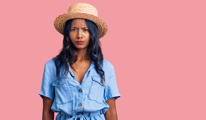 Young indian girl wearing summer hat skeptic and nervous, frowning upset because of problem....