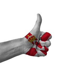 Hand making thumbs up sign, northern ireland painted with flag as symbol of thumbs up, like, okay, positive  - isolated on white background