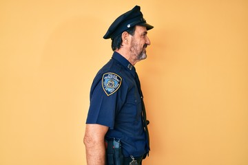 Middle age hispanic man wearing police uniform looking to side, relax profile pose with natural...