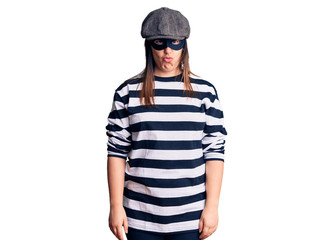 Fototapeta premium Young beautiful brunette woman wearing burglar mask skeptic and nervous, frowning upset because of problem. negative person.