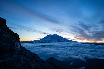 Panoramic view of Mount Rainier above the clouds during the sunrise with dramatic color in the sky