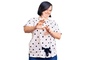 Brunette woman with down syndrome wearing casual clothes disgusted expression, displeased and...