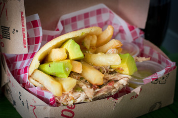 Corn arepas stuffed with beef, chicken breast, pork ham, mozzarella cheese and avocado.corn arepa with sausages, sausage meat. pork sausage, grilled sausages. 
