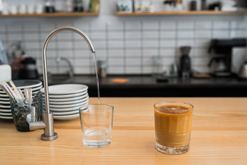 water is pouring from a tap into a glass