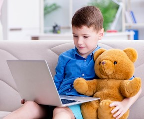Little boy surfing internet on laptop