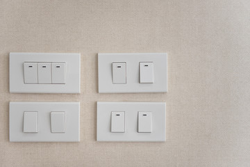 White lighting switchs on concrete wall.