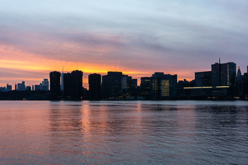 Fototapeta na wymiar Sunset of Manhattan Skyline in New York City. Silhouette of skyscrapers along East River