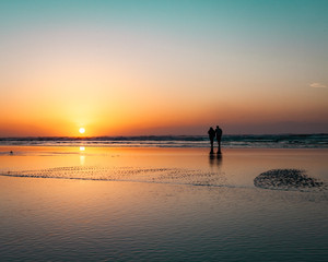 Fototapeta premium couple on the beach at sunrise