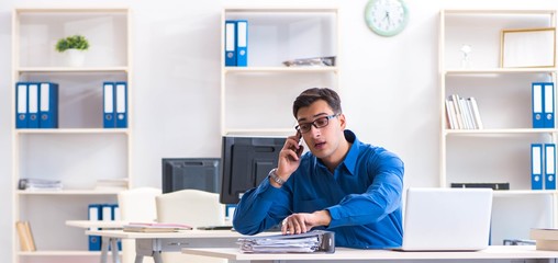 Handsome businessman employee sitting at his desk in office
