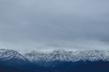 Amazing cloudy sky over the snowed Los Andes mountains, Chile