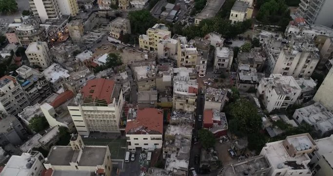 2020 Beirut port explosion: aerial view of debris and downtown skyscrapers and rooftops destroyed by ammonium nitrate blast in industrial warehouse, Lebanon, overhead tilt down drone approach