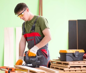 Young man carpenter working in workshop