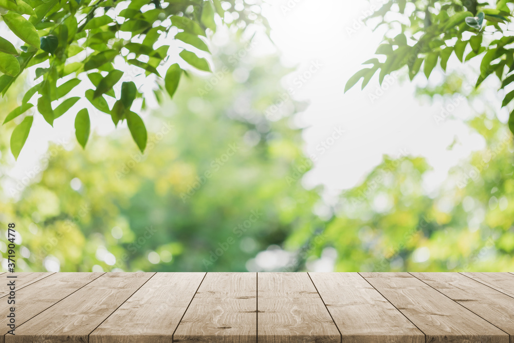 Wall mural empty wood table top and blurred green tree in the park garden background - can used for display or 