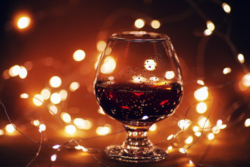 Delicate background with a glass of red finale on an aesthetically blurred orange background with backlight and bokeh.