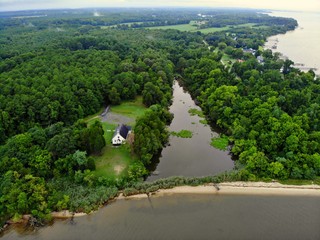 The aerial view of a small river, green trees and a white beach near Rock Point, Maryland, U.S.A