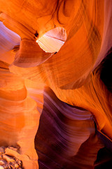 Gaping eye sockets of natural landscape in Lower Antelope Canyon in Page Arizona with bright sandstones stacked in flaky fire waves in a narrow sandy labyrinth with caves
